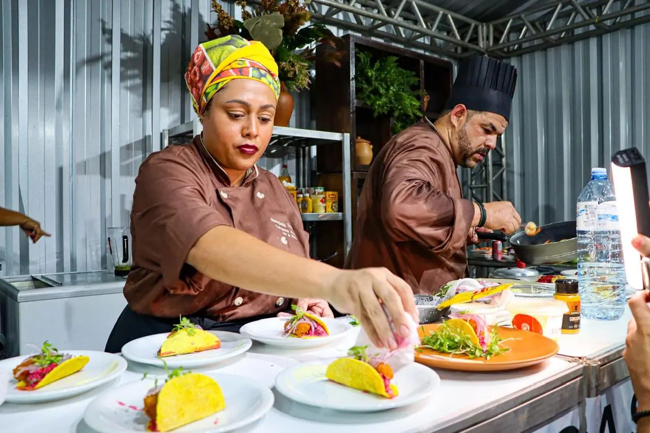 Os chefs Dorys Mirta e Tatyanne Almeida finalizando pratos lado a lado na cozinha